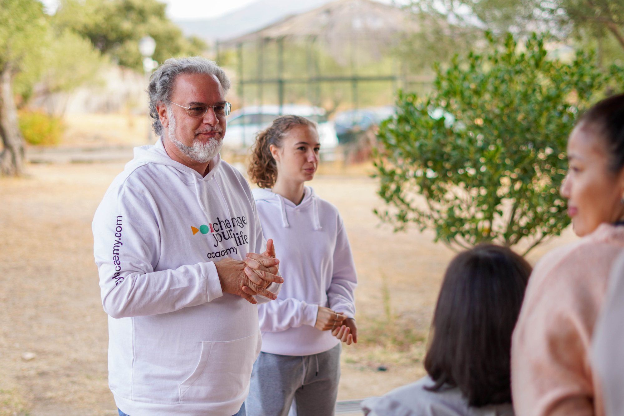 Filippo sorridente con alcune partecipanti all'aperto, alla Finca de la Paz