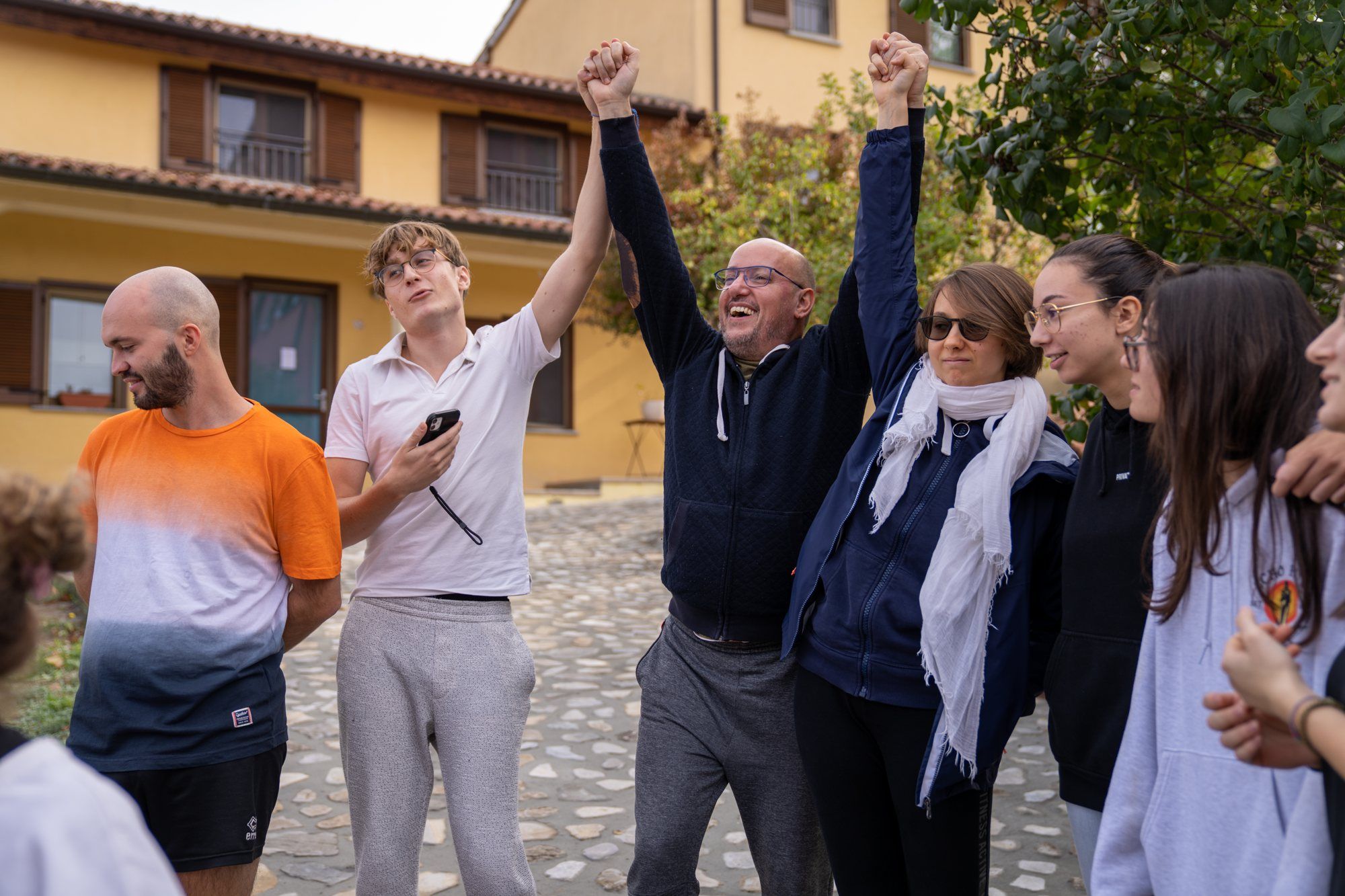 Filippo fait la fête, les bras levés, avec un groupe de participants
