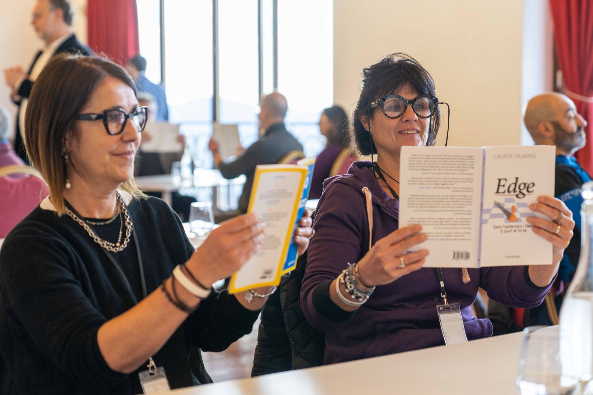 Deux participants souriants, un livre à la main, pendant Leadership