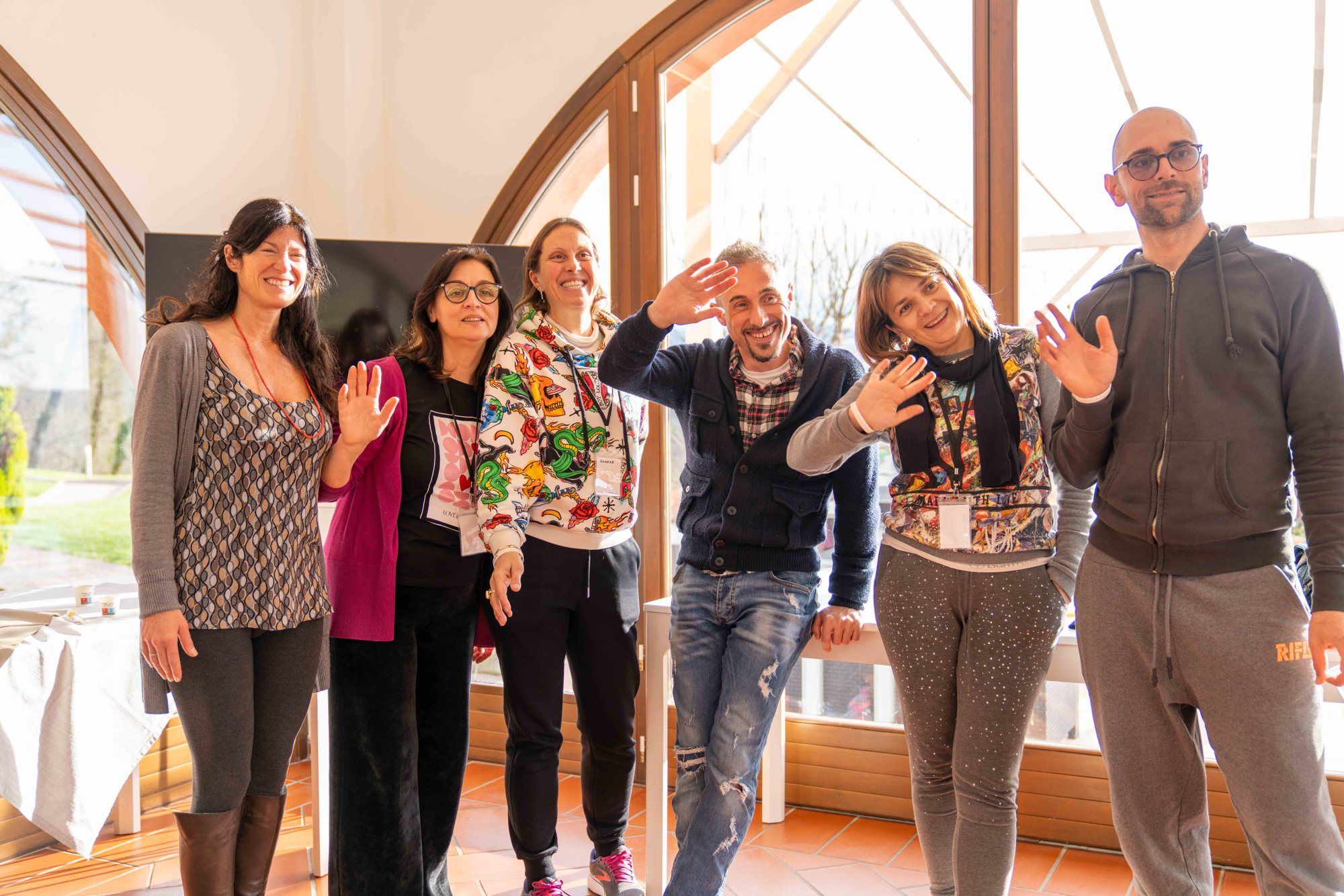 A group of participants wave and smile during Leadership