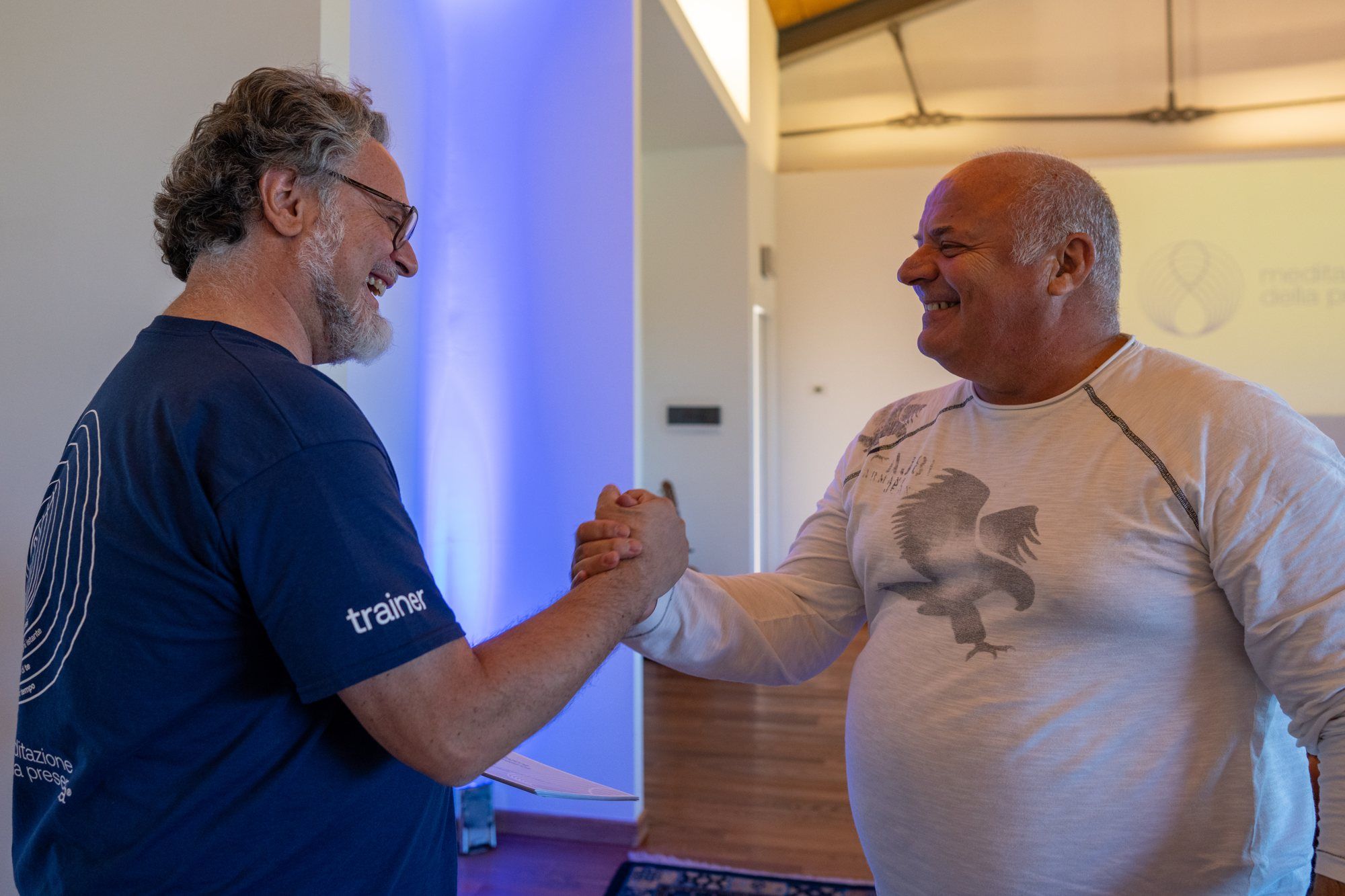Filippo smiles and shakes hands with a participant in the Master di Meditazione della Presenza